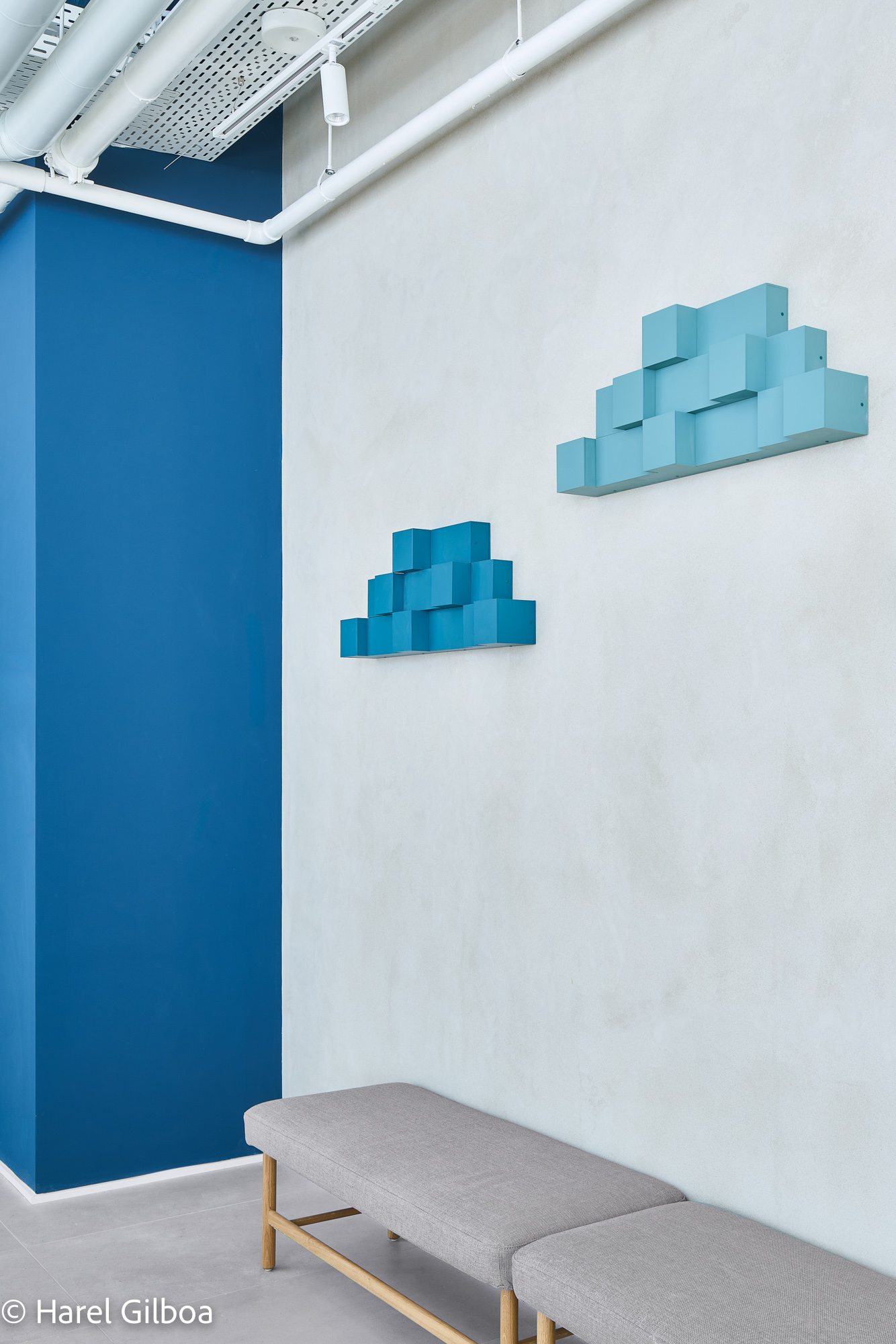 Two pixel-cloud reliefs in graded blues floating on the wall.