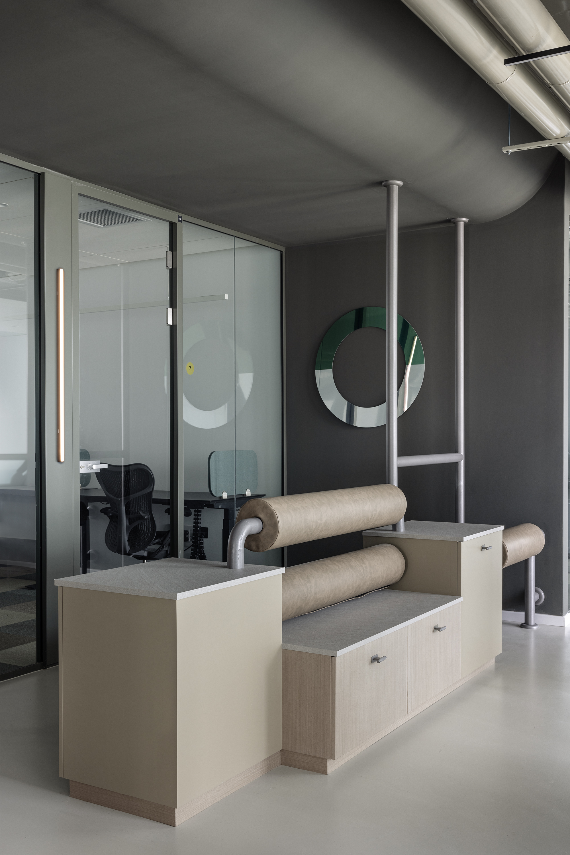 A ring mirror in graded green over the leather console.